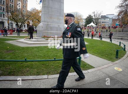 Vancouver, Kanada. November 2020. Ein Mitglied der kanadischen Streitkräfte geht während der Gedenkfeier am Victory Square in Vancouver, British Columbia, Kanada, am 11. November 2020 am Kenotaph vorbei. Aufgrund der COVID-19-Pandemie fand der diesjährige Gedenktag im Rahmen von Maßnahmen zur Gesundheitssicherheit statt. Der Siegesplatz war für die Öffentlichkeit geschlossen und erlaubte nur einer begrenzten Anzahl von Teilnehmern, an der Zeremonie teilzunehmen. Quelle: Liang Sen/Xinhua/Alamy Live News Stockfoto