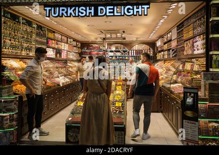 Menschen mit Gesichtsmasken einkaufen in einem türkischen Delight-Shop mit türkischen Gewürzen, Tee und Desserts, Istanbul, Türkei Stockfoto