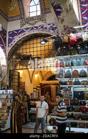 Ladenarbeiter stehen vor einem türkischen Handtaschen- und Parfüm-Souvenirladen im Großen Basar, Istanbul, Türkei Stockfoto