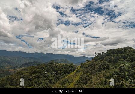 Petropolis, Brasilien - 23. Dezember 2008: Grüne bewaldete Berge von Fluminence reichen unter blauer Wolkenlandschaft rund um die Stadt. Stockfoto