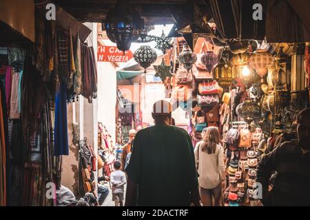 Marrakesch, Marokko - APRIL 26 2019: Blick auf ein Geschäft mit vielen Produkten auf einer belebten Straße in Medina Stockfoto