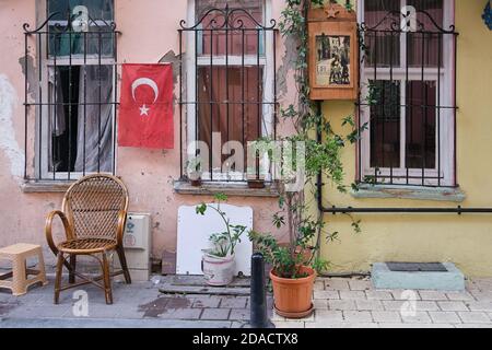 Blick auf die Vorderseite eines Hauses auf der Rückseite Die Straßen von Balat mit den Fensterbars eine türkische Flagge und Eine hölzerne Briefkiste mit einem Plakat des Films Das Leben ist sein Stockfoto