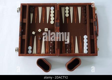 Ein Backgammon-Set, das für zwei Personen auf weißem Hintergrund gespielt werden kann. Stockfoto