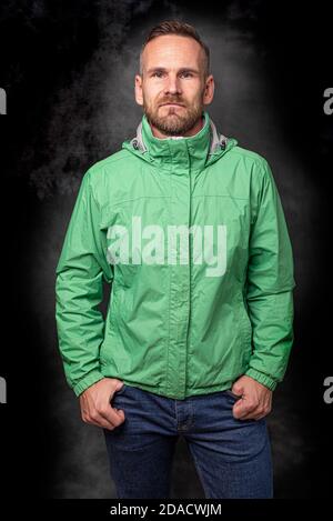 Hübscher stilvoller Mann, der auf dunklem Hintergrund posiert Stockfoto