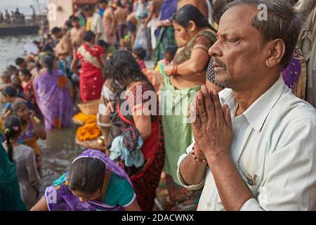 Varanasi, Indien, November 2015. Ein Mann betet in einem Ganges River Ghat in der Morgendämmerung. Stockfoto