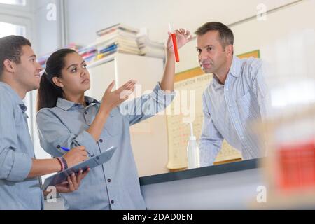 Wissenschaft Lehrer beobachten Schüler tun Experiment Stockfoto