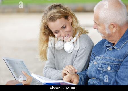 Lächelnde Frau mittleren Alters und ihr Vater Blick auf digitale Tablet Stockfoto