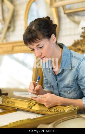 Kunsthandwerkerin, die an der Dekoration von Holzrahmen arbeitet Stockfoto