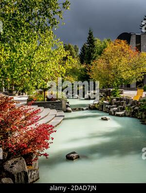 Das türkisfarbene Wasser des Teichs im Village Park auf dem Village Spaziergang am Olympic Plaza im Dorf Whistler, British Columbia, Kanada Stockfoto