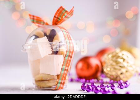 Box mit Satinbändern und leckeren Leckereien für Neujahr und Weihnachten. Neujahrsdesserts auf hellem Hintergrund. Frohe weihnachten Stockfoto