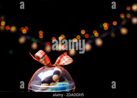 Box mit Satinbändern und leckeren Leckereien für Neujahr und Weihnachten. Neujahrsdesserts auf dunklem Hintergrund. Inhalte für das neue Jahr Stockfoto