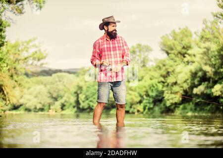 Ruhige und friedliche Stimmung. Fischer allein im Wasser des Flusses. Mann bärtigen Fischer. Fischer Angelausrüstung. Eine Art der Meditation. Fische in der Regel in freier Wildbahn gefangen. Trout Farm. Hobby Sport. Stockfoto