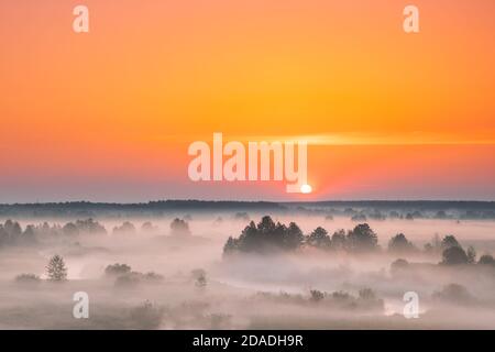 Toller Sonnenaufgang Sonnenuntergang Über Der Misty Landschaft. Landschaftlich Schöner Blick Auf Den Nebligen Morgenhimmel Mit Aufgehender Sonne Über Dem Misty Forest Und Dem Fluss. Frühsommer Natur Von Stockfoto