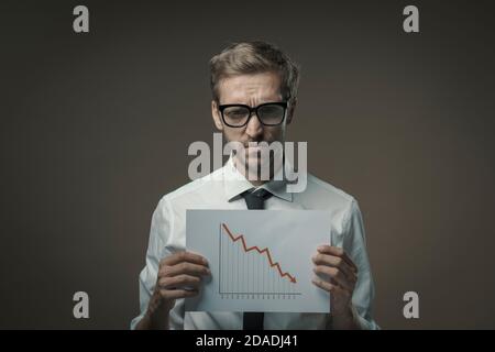 Traurige Geschäftsmann mit einem negativen Finanzdiagramm, Konkurs und Finanzkrise Konzept Stockfoto