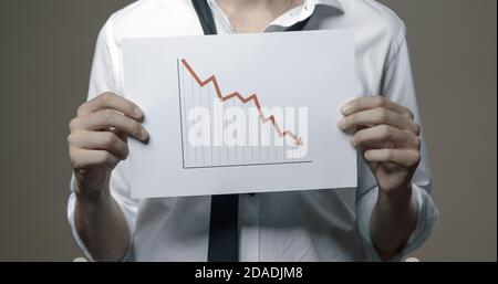 Geschäftsmann mit einem negativen Finanzdiagramm, Konkurs und Finanzkrise Konzept Stockfoto