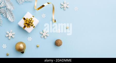 Geschenkschleife mit weihnachtlichen goldenen Verzierungen auf blauem Hintergrund Stockfoto