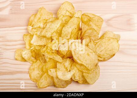 Kartoffelchips. Stapel von Kartoffelchips auf einem Holztisch. Knusprige Kartoffelchips. Junk-Food-Konzept Stockfoto