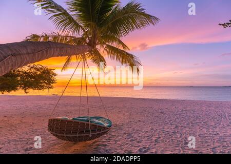 Tropischer Sonnenuntergang Strand Hintergrund als Sommerlandschaft Panorama mit Strand Schaukel Hängematte und weißem Sand und ruhigen Meer Strand Banner. Perfekte Strandszene Stockfoto