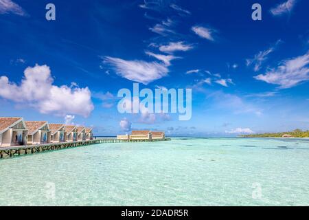 Luxuriöse Wasservillen in tropischer Meereslagune, flaches Meerwasser in der Nähe der paradiesischen Insel. Strandresort Landschaft, Sommerurlaub, Urlaubsziel Stockfoto