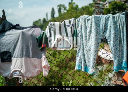 ITAGUI, KOLUMBIEN - 16. März 2019: Itagui, Antioquia / Kolumbien - 15 2019. März: Kinderkleidung Aufhängen und Trocknen der Sonne über einem Zaun Stockfoto