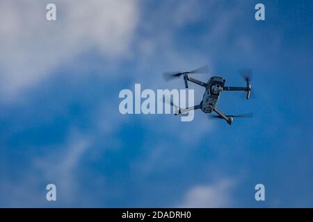 Drohne fliegende Drohne auf einem verschwommenen Hintergrund der Natur. Moderne Technologie, Überwachung, digitale Medien, Content-Erstellung, Fotografie und Video Stockfoto