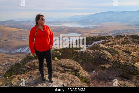 RENO, NEVADA, VEREINIGTE STAATEN - Nov 11, 2020: Eine Wanderin steht auf einem Gipfel der Great Basin Desert mit Washoe Lake und Washoe Valley in der Stockfoto