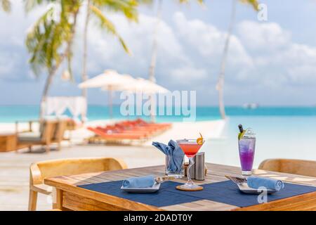 Luxus Resort Outdoor Restaurant Tisch mit Strandliegen, in der Nähe von Infinity-Pool in tropischer Landschaft. Exotischer Sommerurlaub Urlaub Hintergrund Stockfoto