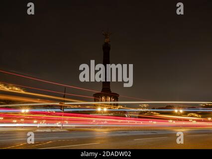 Berlin, Deutschland. November 2020. Die Siegessäule liegt im Dunkeln, während die Fahrzeuge vorbei fahren. (Aufgenommen mit einer Langzeitbelichtung) Credit: Paul Zinken/dpa-Zentralbild/ZB/dpa/Alamy Live News Stockfoto