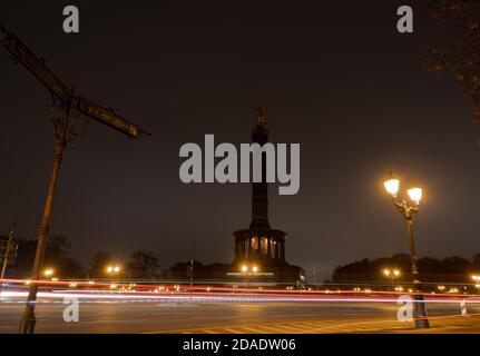 Berlin, Deutschland. November 2020. Die Siegessäule liegt im Dunkeln, während die Fahrzeuge vorbei fahren. (Aufgenommen mit einer Langzeitbelichtung) Credit: Paul Zinken/dpa-Zentralbild/ZB/dpa/Alamy Live News Stockfoto