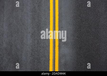 Gelbe doppelte durchgezogene Linie. Straßenmarkierungen auf Asphalt auf der Straße von Manhattan in New York City Stockfoto