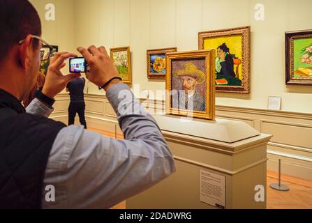 Besucher fotografiert Vincent Van Goghs Gemälde von 1887, Selbstporträt mit Strohhut. Ausgestellt im Metropilitan Museum of Art, New York City, N Stockfoto