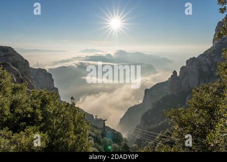 Seilbahn nach Montserrat außerhalb von Barcelona mit Sonnenaufgang oben Wolkenmeer im Wintermorgen Stockfoto