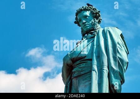 Moskau Russland 06 10 2019: Denkmal für den Dichter Alexander Sergejewitsch Puschkin, Nahaufnahme auf dem Hintergrund des bewölkten Himmels. Eine Taube sitzt auf dem Kopf des Stockfoto