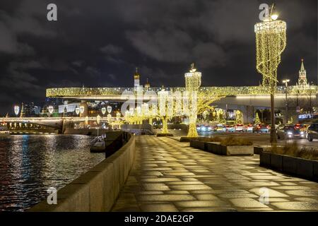 Blick auf Sarjadje Park, hoch aufragende Brücke über den Fluss Moskau, den Kreml und Pokrovsky Kathedrale auf Neujahr und Weihnachtsferien am Abend - M Stockfoto