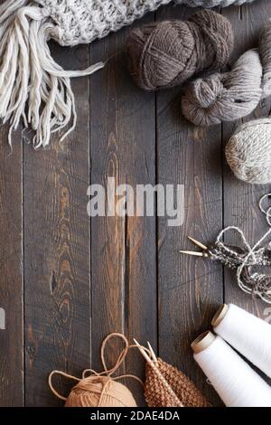 Hohe Winkel Ansicht von Holztisch mit Kugeln aus Garn Und fertig Wollkleidung darauf Stockfoto