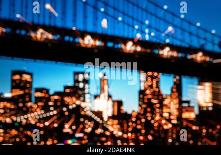 Verschwommene Lichter der Skyline von Manhattan und der Manhattan Bridge bei Nacht. Manhattan Bridge ist eine Hängebrücke, die den East River in New York Cit überquert Stockfoto