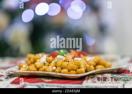 Hausgemachte Süße italienische Struffoli, Mürbeteigkugeln gebraten und in Honig mit Streuseln getaucht. Typisches neapolitanisches Dessert der Weihnachtsfeiertage. Stockfoto