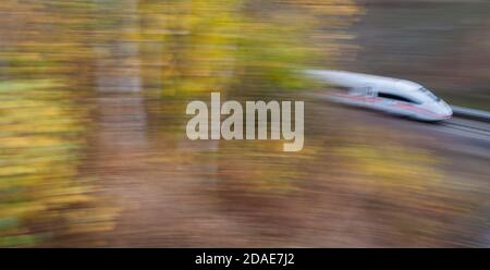 Sorsum, Deutschland. November 2020. Auf der Schnellstraße Hannover-Göttingen im Stadtteil Hildesheim fährt ein ICE der Deutschen Bahn an herbstlich verfärbten Bäumen vorbei (Aufnahme mit langer Verschlusszeit). Die Deutsche Bahn lässt ihre Kunden viel seltener warten als im vergangenen Herbst. Wie bereits im September waren 78.8 Prozent der Fernzüge im Oktober pünktlich, so ein Bahnsprecher der Deutschen Presseagentur. Damit stieg der Pünktlichkeitswert für ICE und Intercities gegenüber Oktober 2019 um 5.8 Prozentpunkte. Kredit: Julian Stratenschulte/dpa/Alamy Live Nachrichten Stockfoto