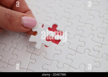 Womans Hand Platzierung letzten Puzzleteil auf Tisch Nahaufnahme Stockfoto
