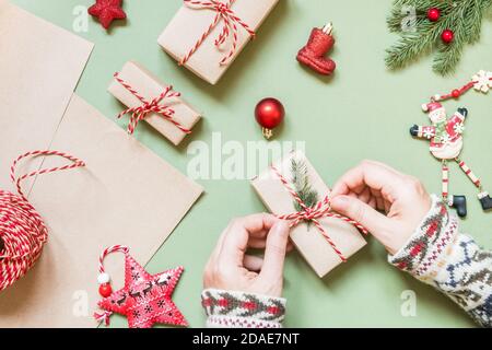 Damenhänden binden eine Schleife auf einem Weihnachtsgeschenk. Stockfoto