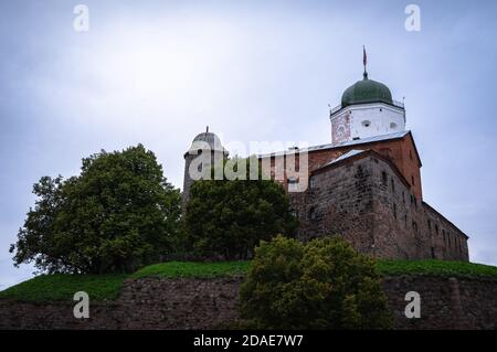 Schloss Vyborg auf dem Hügel inmitten von Bäumen Stockfoto