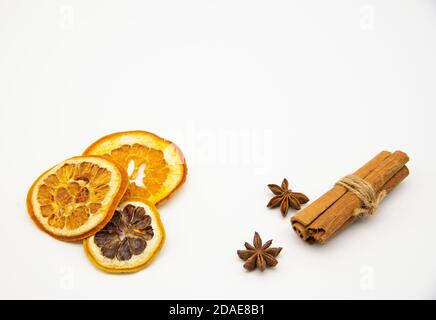 Ein paar Scheiben getrocknete Orange, Zimtstangen und Sternanis auf weißem Hintergrund. Stockfoto