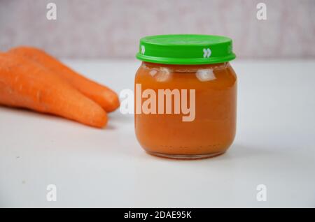 Babynahrung, Baby in einem Glas püriert, Karotten in Scheiben geschnitten Stockfoto