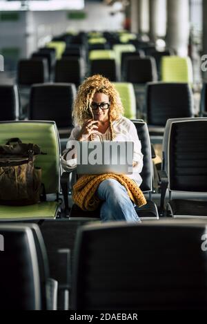 Einsame Erwachsene Frau wartet am Flugsteig auf sie Flug - Konzept des digitalen Nomaden und Internet-Verbindung - Verspätung und Annullierung von Reiserechten für Touristen und Arbeitnehmer Stockfoto