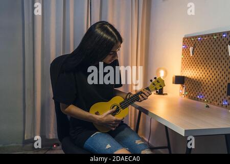 Nahaufnahme einer jungen Dame, die die Ukulele spielt Stockfoto