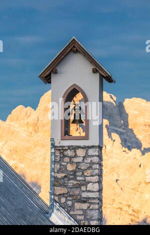 Kapelle der Alpini (Cappella degli Alpini) Glockenturm, am Fuße des Tre Cime di Lavaredo, auf dem Hintergrund der Monte Cristallo von der Sonne geküsst, Dolomiten Berge, Auronzo di Cadore, Provinz Belluno, Venetien, Italien, Europa Stockfoto