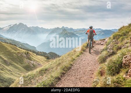 Junger Mann (22 Jahre alt) mit E-Bike auf einem alpinen Weg, Campitello di Fassa, Fassatal, Trient, Trentino Alto Adige, Italien Europa Stockfoto