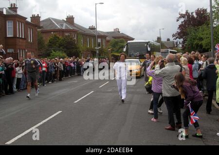 Ayrshire, Schottland, Großbritannien. Die London 2012 Olympic Fackel reist durch South Ayrshire, angefeuert von lokalen Gemeinden und Schulkindern. Fackelträger heruntergekommen Monument Rd, Ayr Stockfoto