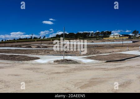 Am Stadtrand von Melbourne Australien wird ein neues Anwesen gebaut, schwere Maschinen haben den Hang terraformt, Straßen wurden verlegt. Stockfoto