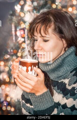 Mädchen genießt den Geruch eines heißen Getränks in der Weihnachten Hintergrund Stockfoto